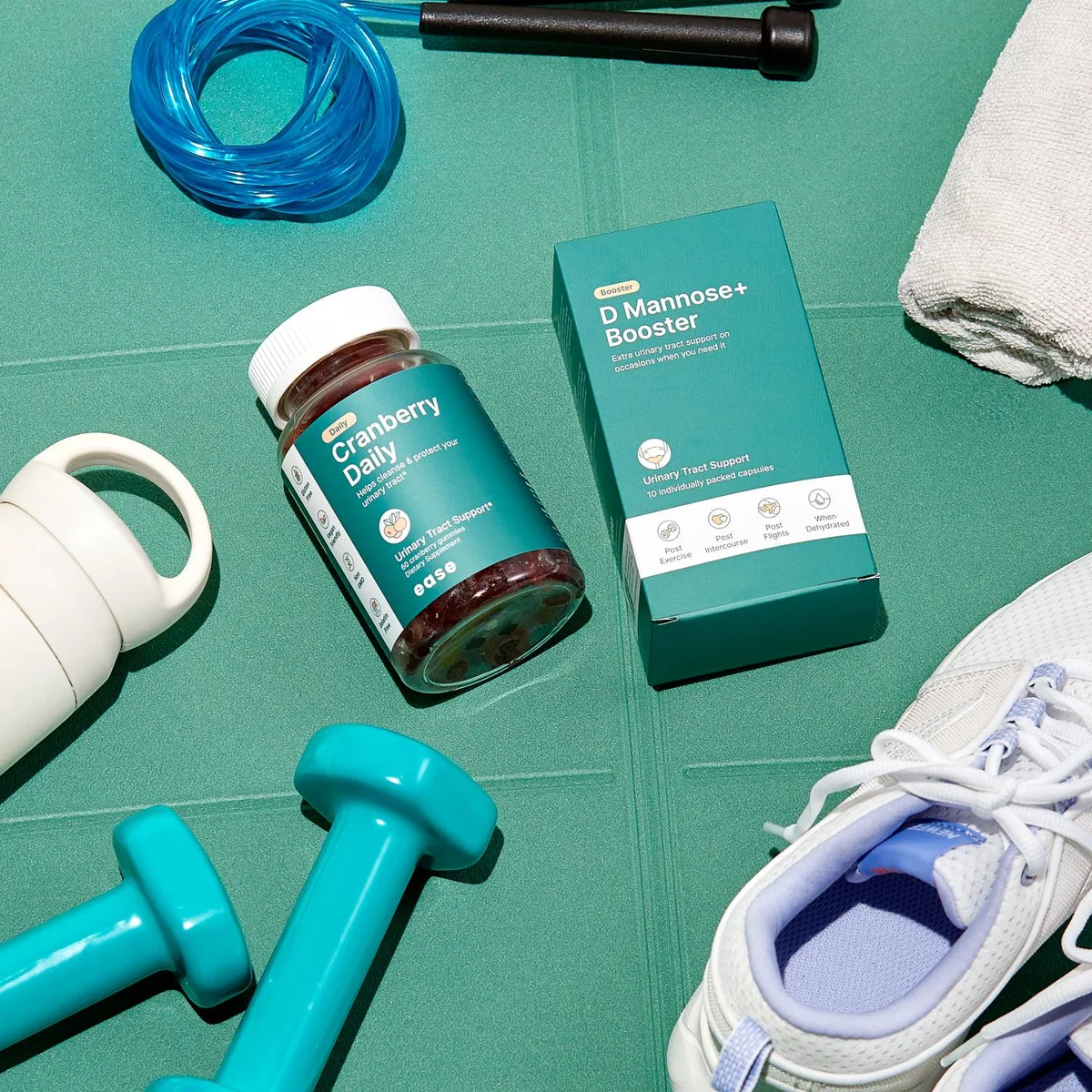 Ease cranberry gummies and booster box on a gym mat