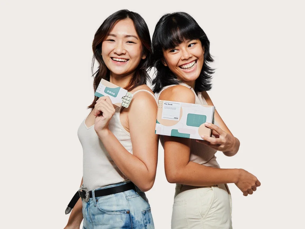 Two friends holding Ease packaging back to back
